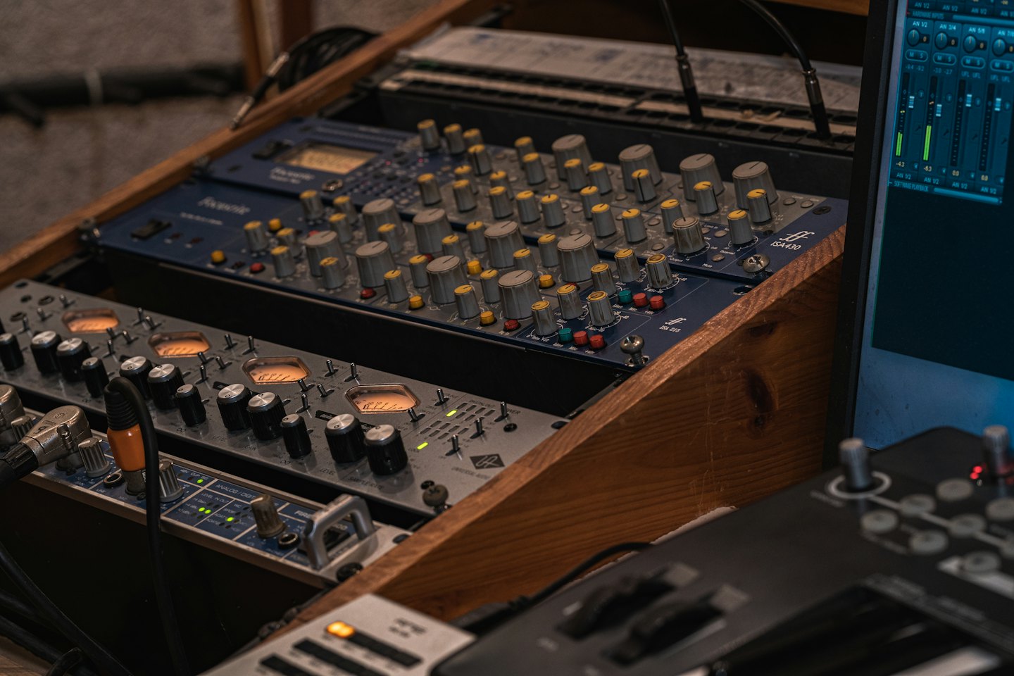 Equipo de mezcla de audio profesional en un mueble de madera.