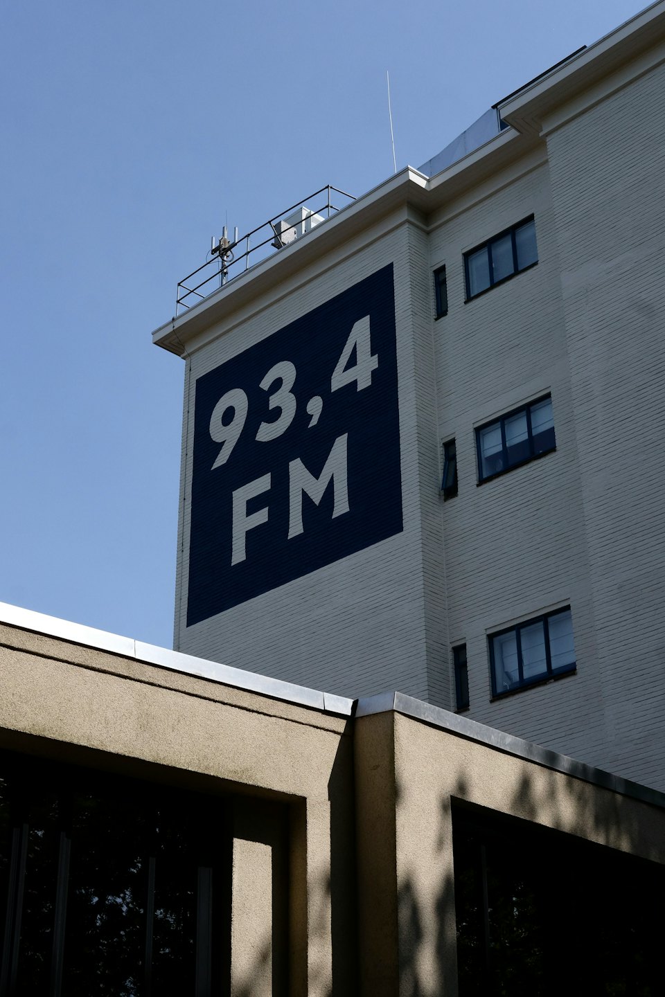 Edificio de estación de radio con 93.4 FM pintado en la pared.